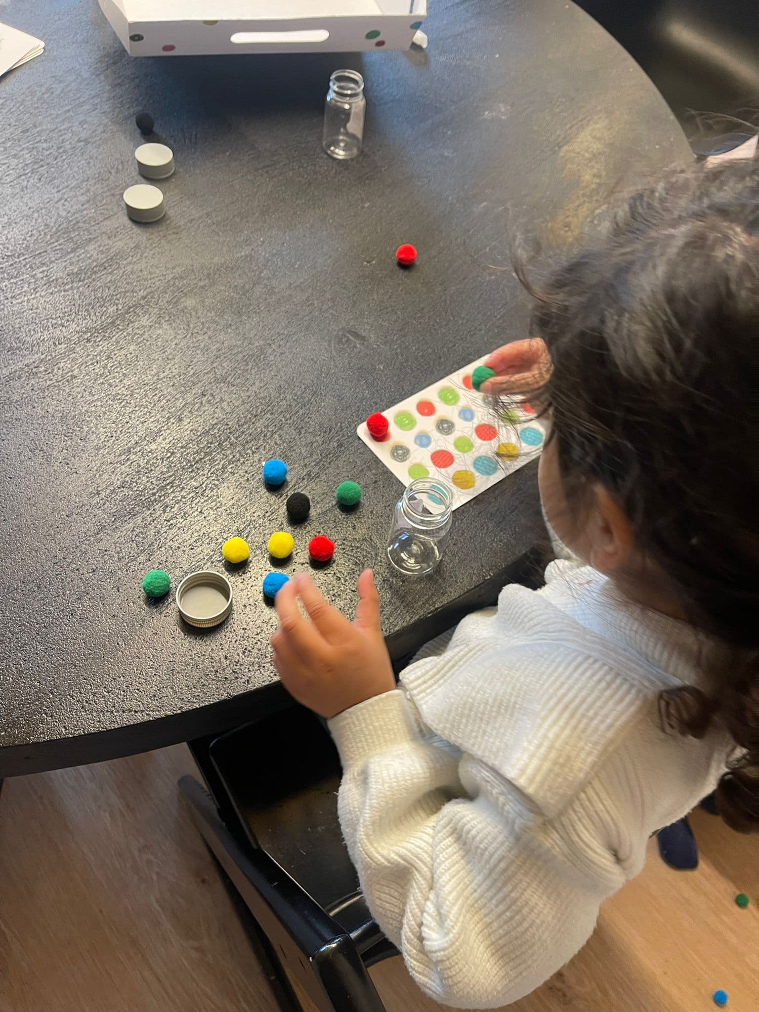 Kind speelt geconcentreerd met kleurrijk spelmateriaal