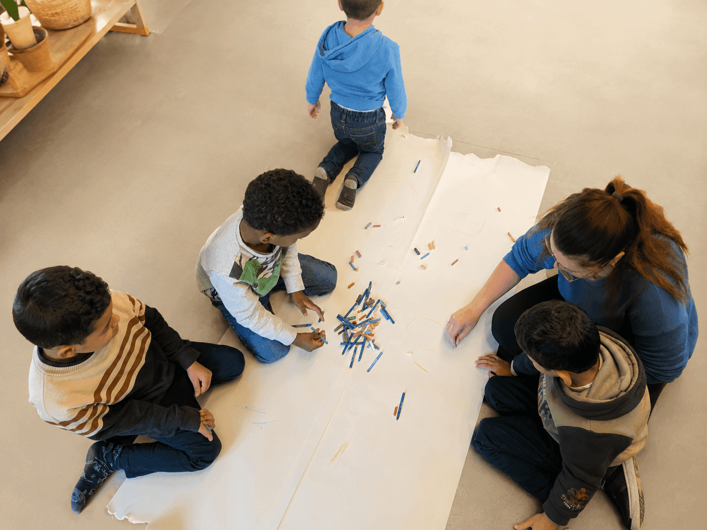 Begeleider tekent samen met een groep kinderen bij Samen Sterk